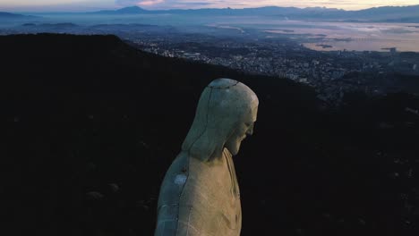 Aerial-view-closely-around-the-face-of-the-Cristo-Redentor-statue-in-Rio-de-Janeiro,-dusk-in-Brazil