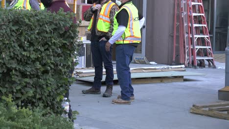 construction-workers-stand-around-building