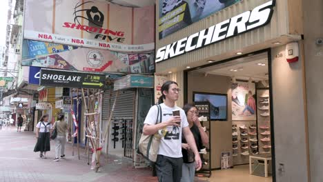 Los-Clientes-Chinos-Son-Vistos-En-La-Tienda-Skechers-De-La-Marca-Estadounidense-De-Calzado-De-Estilo-De-Vida-Y-Rendimiento-Mientras-Los-Peatones-Pasan-Por-Delante.