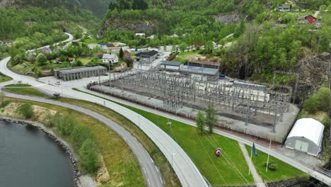 Hydroelectric-powerstation-high-voltage-transformer-and-distribution-network-in-Matre-Norway---Eviny-company-energy-production-in-western-Norway---Aerial-with-power-lines-in-foreground