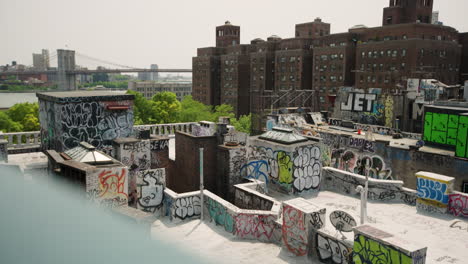 Das-Mit-Graffiti-Bedeckte-Dach-Von-New-York-City-Mit-Der-Brooklyn-Bridge-In-Der-Ferne