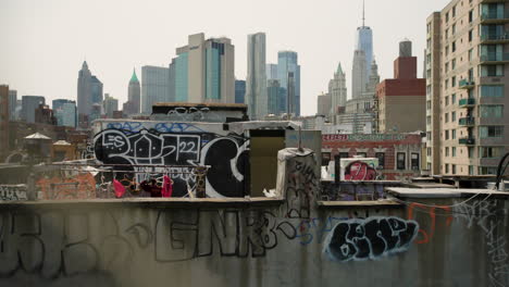 Stark-Mit-Graffiti-Verziertes-Dach-In-Der-Innenstadt-Von-New-York-City-Mit-Den-Finanzvierteltürmen-Im-Hintergrund