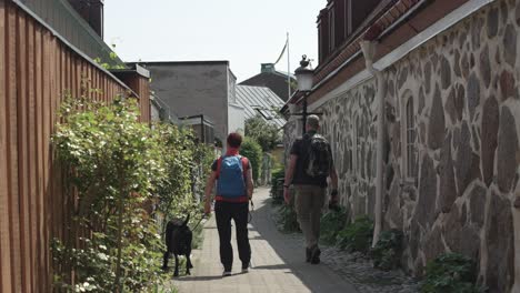 German-tourists-and-local-man-walk-dog-in-city-center-Ystad-Sweden