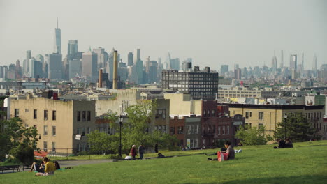 New-Yorker-Finanzviertel-Und-Midtown-Tower-In-Der-Ferne,-Während-Sich-Die-Menschen-Im-Brooklyn-Park-Entspannen