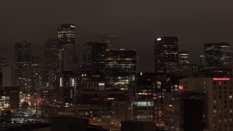 Long-aerial-zoom-shot-with-reveal-of-Denver,-Colorado-skyline-at-night