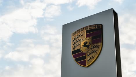 Porsche-Autohaus-Schild-Gegen-Bewölkten-Himmel.-Zeitraffer