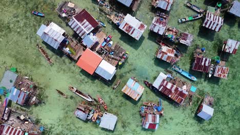 Borneo-aerial-view-of-the-beautiful-water-village-of-the-Bajau-Laut-with-crystal-clear-water-of-Omadal-Sea-in-Sabah,-Malaysia