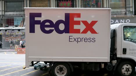 Los-Peatones-Pasan-Junto-A-Un-Camión-Estadounidense-De-Servicios-De-Entrega-Y-Logística-FedEx-Estacionado-En-La-Calle-De-Hong-Kong.