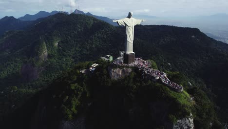 Aerial-view-circling-the-crowded-Mirador-Cristo-Redentor-viewpoint,-overviewing-the-city-of-Rio,-Brazil