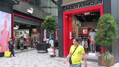 Los-Peatones-Pasan-Por-La-Tienda-De-Ropa-De-La-Multinacional-Estadounidense-Under-Armour-En-Hong-Kong