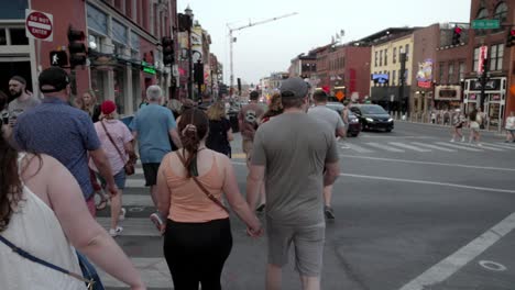 Broadway-Street-in-downtown-Nashville,-Tennessee-with-gimbal-video-following-pedestrians