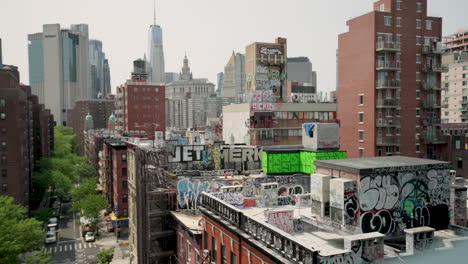 Die-Dächer-Der-Innenstadt-Von-Manhattan-Sind-Mit-Graffiti-Bedeckt,-In-Der-Ferne-Stehen-Die-Wolkenkratzer-Des-Finanzviertels