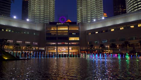 Wunderschöne-Aussicht-Auf-Die-Berühmten-Petronas-Zwillingstürme-Mit-Wasserlichtshow-Bei-Nacht