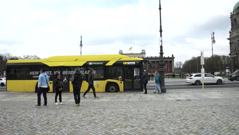 Yellow-Bus-Pulling-Up-To-Stop-Opposite-Lustgarten-In-Berlin