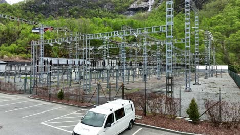 Eviny-Auto-Parkte-Vor-Einer-Riesigen-Umspannstation-Und-Einem-Verteilungsnetz-–-Wasserkraftwerk-Von-Eviny-In-Matre,-Norwegen