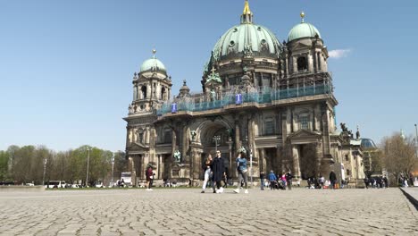 Touristen,-Die-An-Einem-Sonnigen-Tag-Mit-Klarem-Blauen-Himmel-Vorbeigehen-Und-Fotos-Im-Hintergrund-Des-Berliner-Doms-Machen