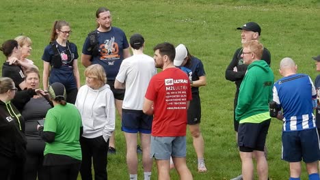 Un-Grupo-De-Corredores-Se-Reunió-Para-Conversar-Y-Apoyarse-Mutuamente-En-El-Campo-Del-Parque-Local-Al-Inicio-De-Su-Carrera-De-Fitness.