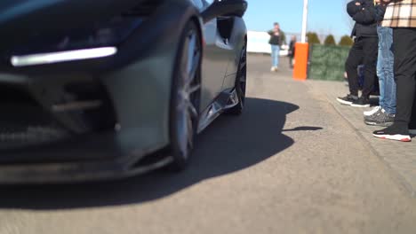 Slow-motion-shot-of-a-Black-Ferrari-passing-by-spectators