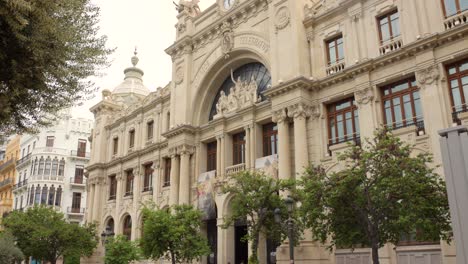 Die-Architektur-Des-Palacio-De-Comunicaciones-Mit-Menschen,-Die-Die-Straße-Entlang-In-Valencia,-Spanien,-Gehen