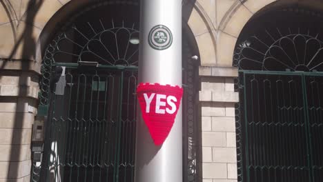 Close-up-of-a-knitted-YES-sign-tied-around-a-pole
