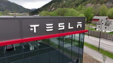Tesla-Autohaus-In-Forde,-Norwegen-–-Nahaufnahme,-Rückwärts-Vom-Großen-Tesla-Logo-An-Der-Ladenwand
