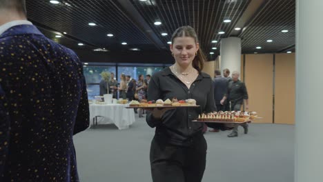 Beautiful-Caucasian-waitress-with-hands-filled-with-canapes-at-elite-party