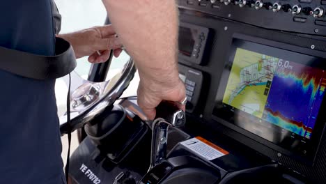 Captain-of-a-fishing-yacht-operating-the-steering-and-console,-Close-up-shot