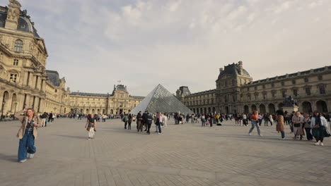 Mucha-Gente-Caminando-Por-La-Entrada-Principal-De-La-Pirámide-Vidriosa-Del-Museo-Del-Louvre