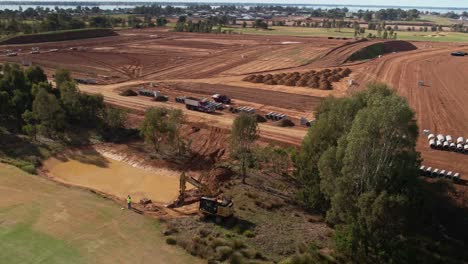 Yarrawonga,-Victoria,-Australia---2-June-2023:-Over-fairway-to-the-tracked-excavator-digging-a-billabong-and-earthworks-of-new-residential-stage-in-the-background