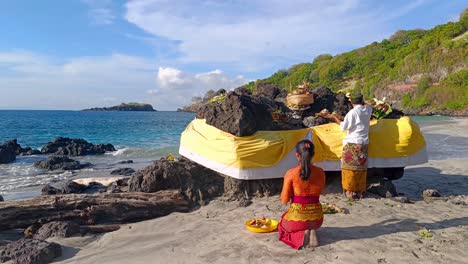 Schöne-Indonesische-Hinduistische-Frauen-Und-Männer,-Nachdem-Sie-Am-Strand-Von-Virgin-Beach-Bali-Gebetet-Und-Dem-Gott-Opfergaben-Dargebracht-Haben
