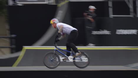 an-athlete-riding-a-BMX-bike-on-an-outdoor-course,-performing-several-upside-down-tricks,at-actual-speed,-during-the-famous-FISE-in-Montpellier,-France,-with-spectators-in-the-background