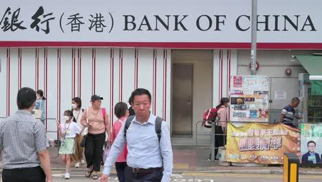 Los-Peatones-Chinos-Caminan-A-Través-De-Un-Paso-De-Cebra-Frente-A-La-Compañía-Bancaria-Comercial-Estatal-China,-El-Banco-De-China,-Sucursal