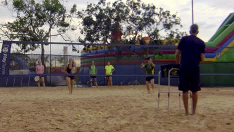 Gente-Atlética-Jugando-Tenis-De-Playa-Al-Atardecer