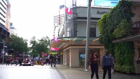 Panning-view-capturing-bustling-Queen-Street-Mall,-popular-pedestrian-shopping-precinct-in-downtown-Brisbane-city,-central-business-district-at-daytime