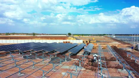 Hermosa-Vista-Del-Paisaje-Con-Nubes-Dramáticas,-Los-Trabajadores-Están-Recogiendo-Los-Paneles-Y-Módulos-Solares-Que-Se-Instalarán-En-La-Estación-De-Energía-Solar-Ubicada-En-La-India