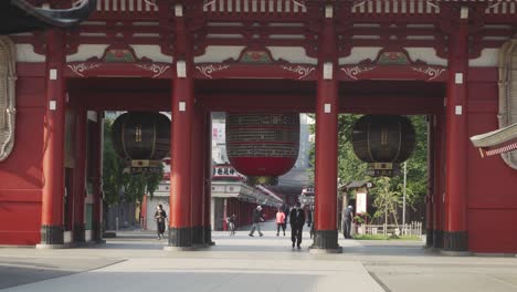 Pedestrians-walking-through-the-Hozomon-Gate-at-Sensoji-Temple-on-a-morning,-oldest-Buddhist-temple-in-Tokyo,-Japan