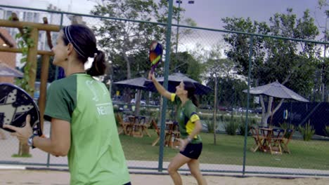 Un-Equipo-De-Mujeres-Atléticas-Jugando-Tenis-De-Playa-Al-Atardecer