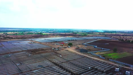 Aerial-drone-camera-moving-forward-where-solar-panels-and-modules-are-being-fitted-in-a-solar-power-station