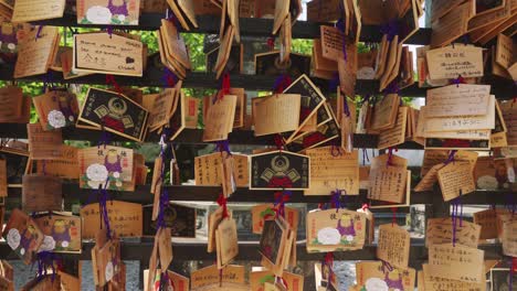 Handheld-truck-left-from-a-display-of-hanging-cards-left-by-tourists-and-visitors-at-the-Toshogu-Shrine-in-Ueno-Park-in-Tokyo,-Japan