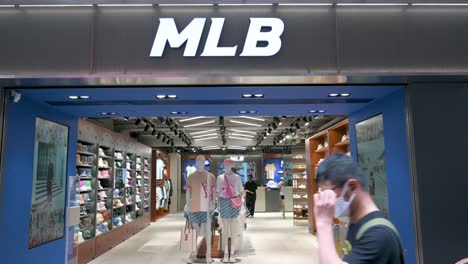 Los-Peatones-Pasan-Por-La-Organización-Estadounidense-De-Béisbol-Profesional,-La-Liga-Mayor-De-Béisbol,-La-Tienda-Oficial-De-Mercancías.