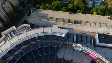 Drone-shot-tilting-over-the-Yankee-stadium,-revealing-the-cityscape-of-Concourse,-golden-hour-in-Bronx,-NY,-USA