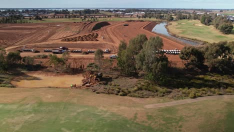 Yarrawonga,-Victoria,-Australia---2-June-2023:-Over-fairway-to-the-tracked-excavator-digging-a-billabong-and-earthworks-of-new-residential-stage-in-the-background