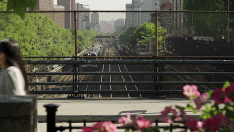 New-York-City-Commuter-Train-Passes-Under-Street-While-Pedestrians-Walk-Above