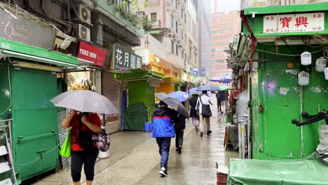 Menschen,-Die-Während-Eines-Regensturms-In-Hongkong-Auf-Der-Tai-Yuen-Straße-In-Wan-Chai-Spazieren