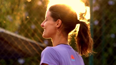 Frau-Feiert-Sieg-Des-Beach-Tennis-Matches-Mit-Sonnenuntergangslicht-Dahinter
