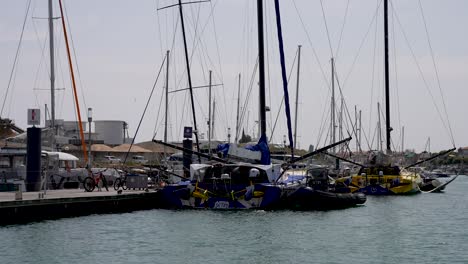 Mann-Betritt-Ein-Segelboot-Im-Yachthafen-Mit-Rechts-Festgebundenem-Beiboot,-Nähernde-Aufnahme-Vom-Schiff-Aus