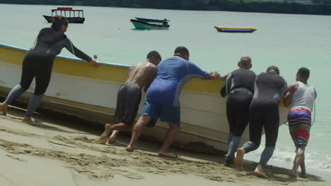 Gente-Empujando-Un-Barco-Hacia-La-Costa-Atlántica-Para-Bucear.