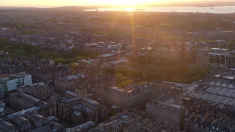 Spectacular-aerial-drone-sunset-over-Edinburgh-centre,-royal-mile-and-St-Giles-cathedral