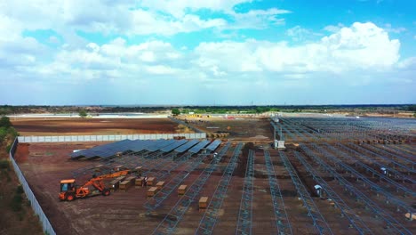 Aerial-front-shot-of-solar-panels-and-modules-being-installed-at-photovoltaics-green-energy-power-station-in-India