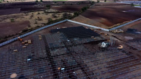 Aerial-drone-camera-moving-backward-above-the-solar-power-station-and-solar-photovoltaic-power-station-in-India